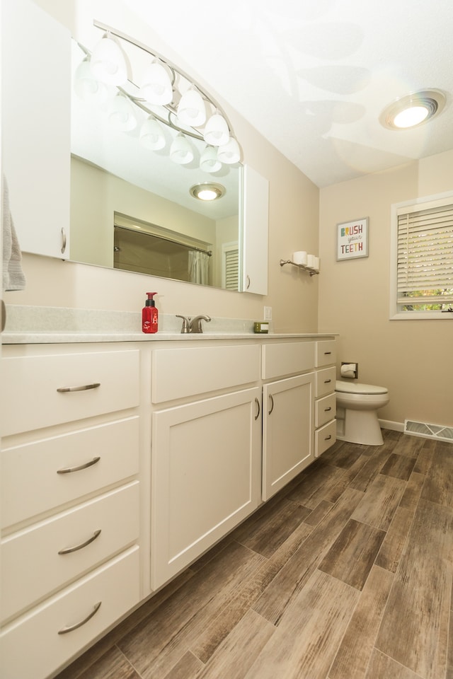 bathroom featuring vanity, hardwood / wood-style floors, and toilet