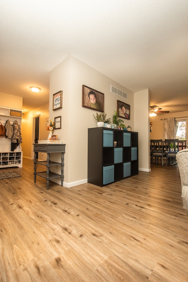 living room featuring light hardwood / wood-style floors and ceiling fan