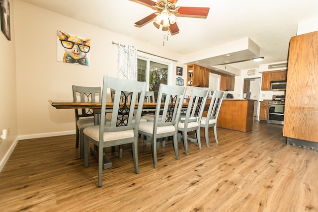 dining room with light hardwood / wood-style floors and ceiling fan