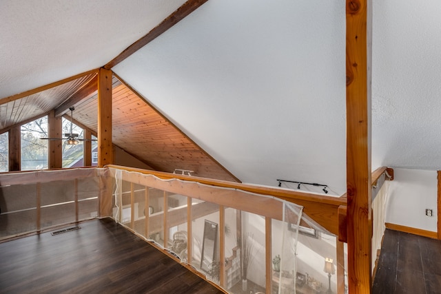 stairs featuring wood-type flooring, a textured ceiling, and vaulted ceiling with beams