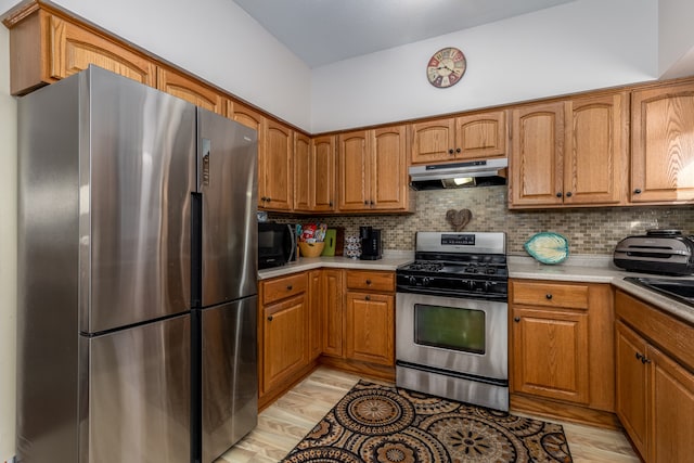 kitchen featuring backsplash, appliances with stainless steel finishes, and light wood-type flooring