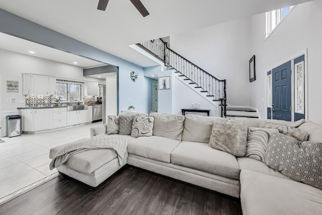 living room with ceiling fan, sink, and light hardwood / wood-style flooring