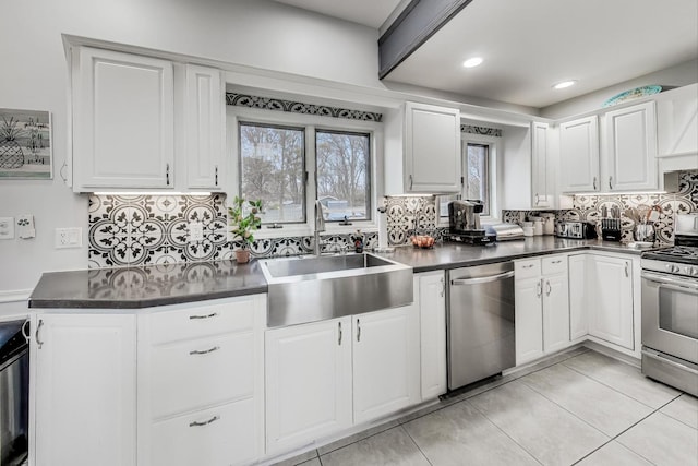 kitchen with backsplash, sink, white cabinetry, and stainless steel appliances