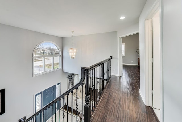 corridor featuring dark hardwood / wood-style flooring and a chandelier