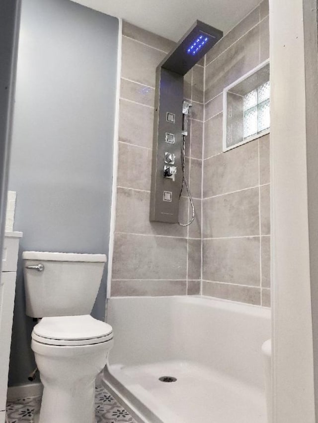 bathroom featuring toilet and tiled shower