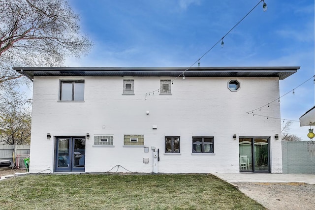 rear view of house with a patio area and a lawn