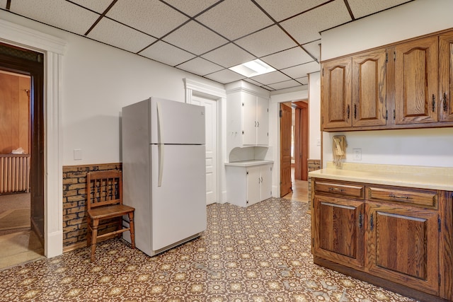 kitchen with a paneled ceiling and white refrigerator