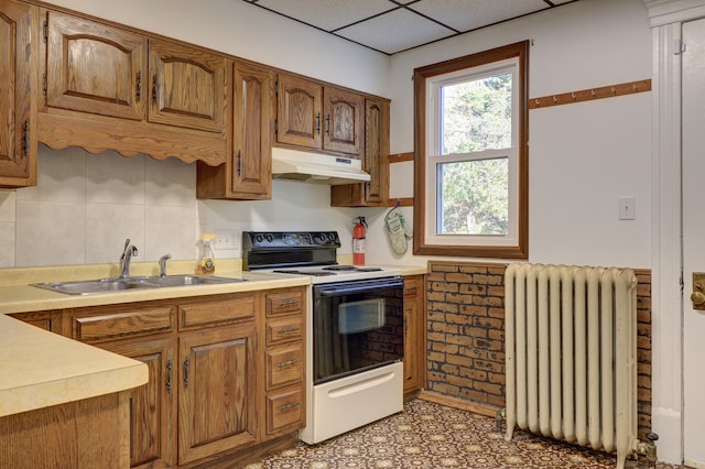 kitchen with radiator heating unit, a paneled ceiling, sink, and electric range