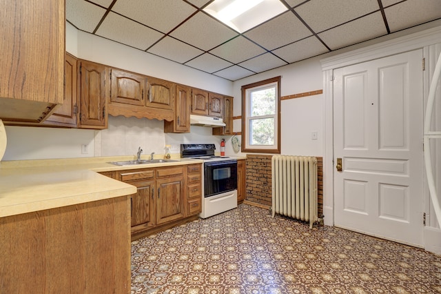 kitchen with a drop ceiling, radiator heating unit, sink, and electric stove