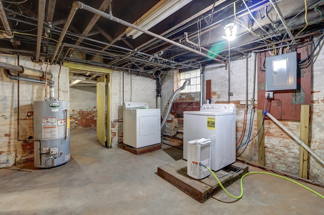 basement with electric panel, gas water heater, and independent washer and dryer