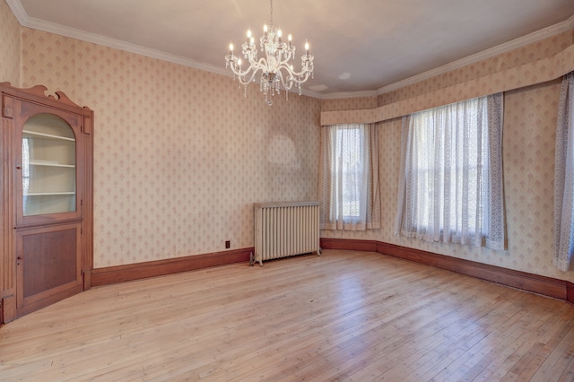 unfurnished dining area featuring ornamental molding, hardwood / wood-style floors, radiator heating unit, and an inviting chandelier