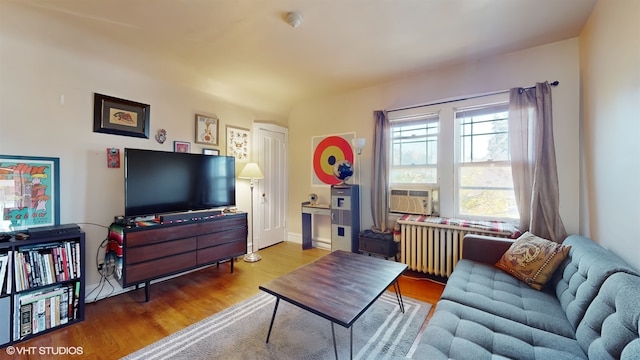 living room featuring hardwood / wood-style floors, radiator heating unit, and cooling unit