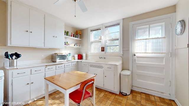 kitchen featuring white cabinetry, plenty of natural light, sink, and ceiling fan