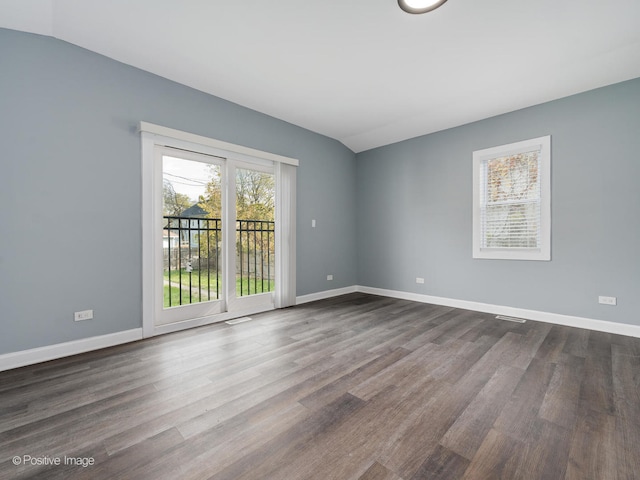 unfurnished room featuring dark wood-type flooring and vaulted ceiling