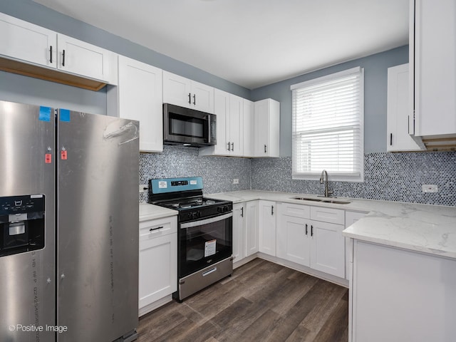 kitchen featuring appliances with stainless steel finishes, sink, backsplash, dark hardwood / wood-style flooring, and white cabinetry