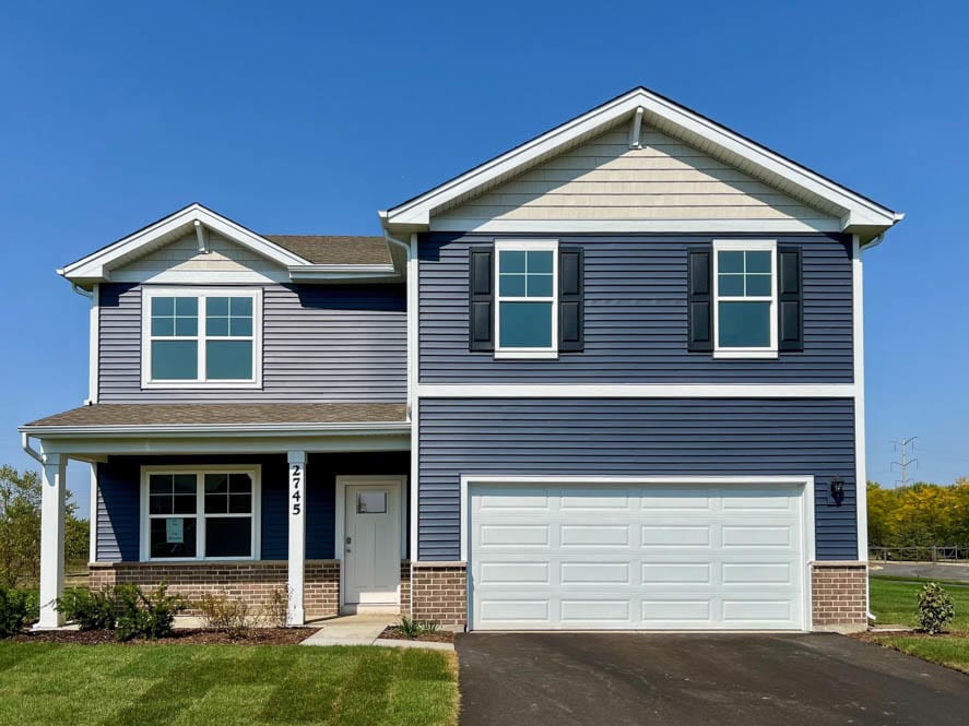 view of front facade with a porch, a front lawn, and a garage