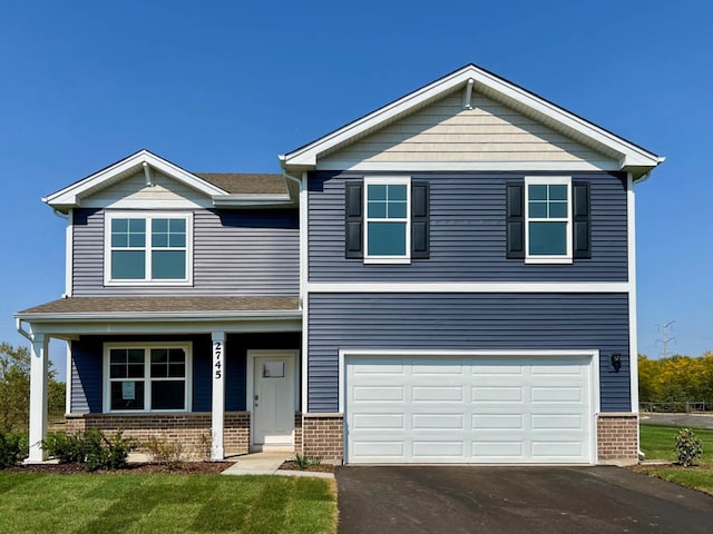 view of front facade with a porch, a front lawn, and a garage