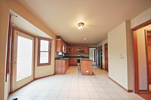 kitchen featuring stainless steel appliances, a kitchen island, and sink