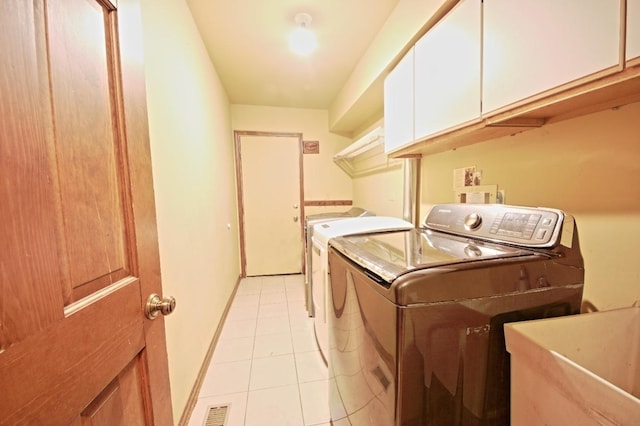 washroom featuring light tile patterned flooring, cabinets, sink, and washing machine and dryer