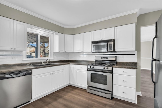 kitchen with dark hardwood / wood-style flooring, white cabinetry, appliances with stainless steel finishes, and tasteful backsplash