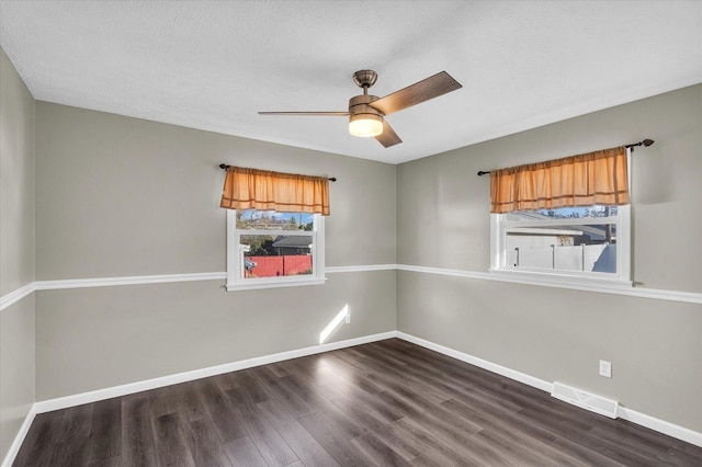 spare room featuring a textured ceiling, ceiling fan, and dark hardwood / wood-style floors