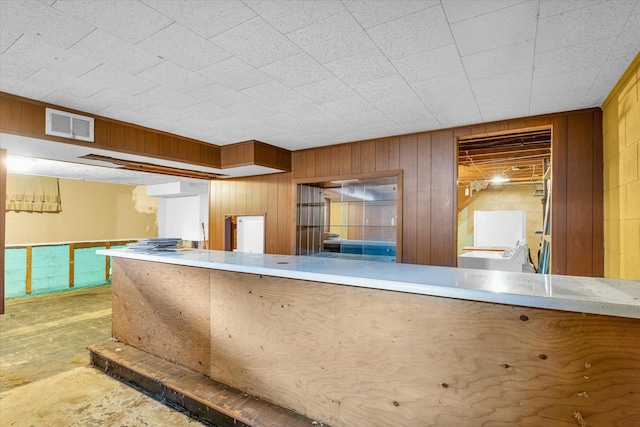 kitchen featuring concrete floors and wooden walls