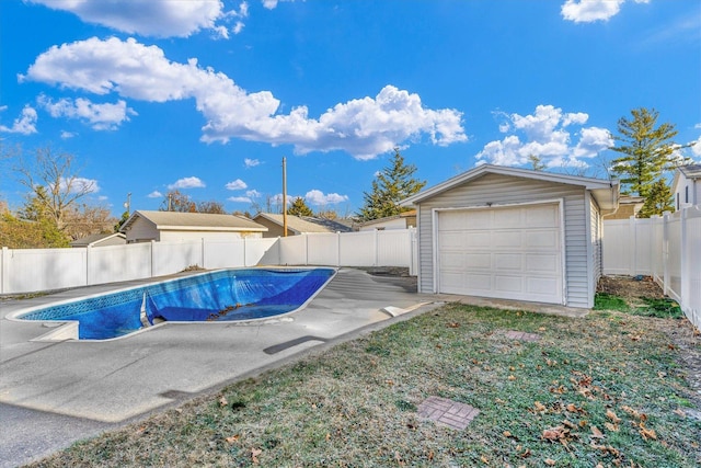 view of swimming pool featuring an outdoor structure and a garage