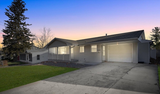 single story home featuring covered porch, a garage, and a yard