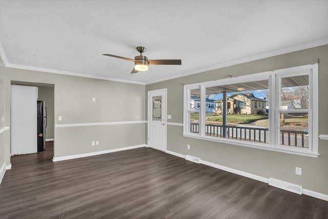 empty room featuring plenty of natural light, ceiling fan, and dark wood-type flooring