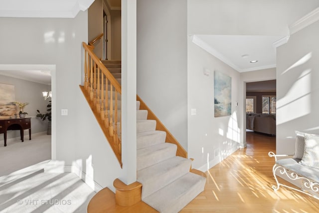 stairs featuring a notable chandelier, wood-type flooring, and ornamental molding