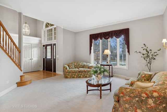 living room with carpet flooring, a chandelier, and crown molding