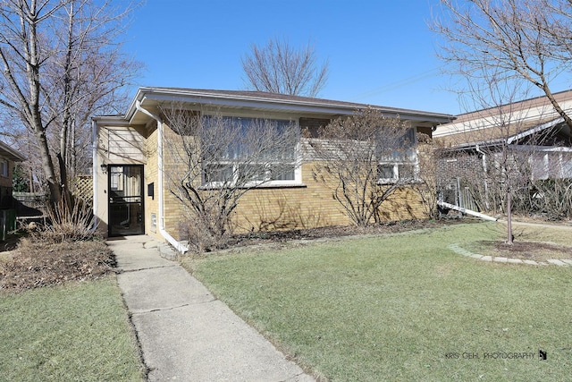 view of front of house with a front yard and brick siding