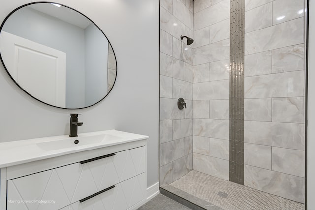 bathroom with a tile shower and vanity