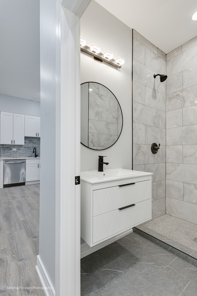 bathroom featuring vanity, wood-type flooring, backsplash, and tiled shower