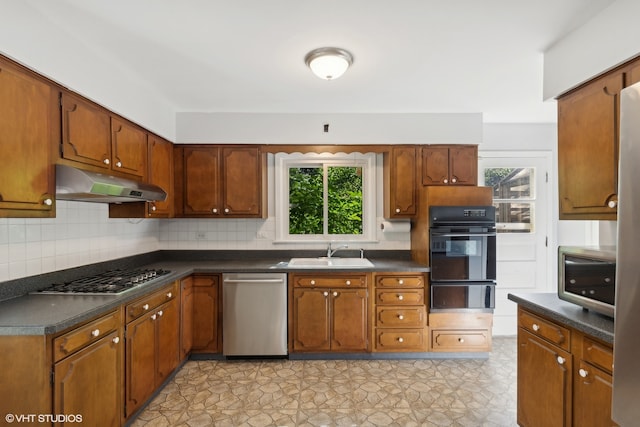 kitchen featuring a healthy amount of sunlight, stainless steel appliances, decorative backsplash, and sink