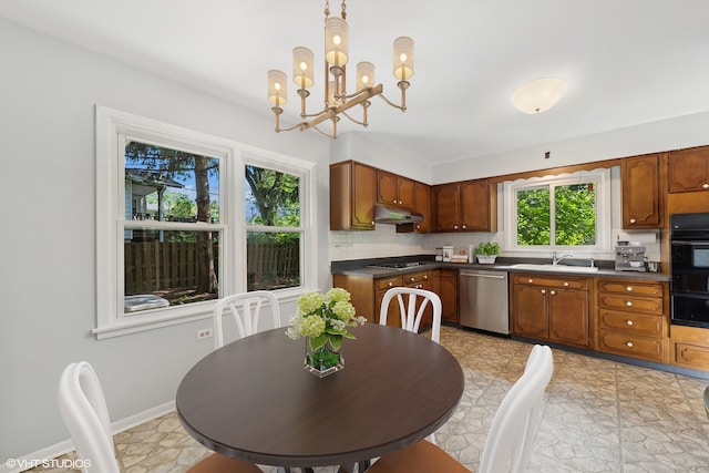 kitchen featuring backsplash, a notable chandelier, appliances with stainless steel finishes, and plenty of natural light