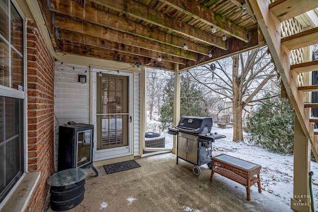 snow covered patio featuring central AC and grilling area