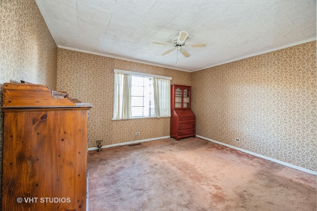 carpeted spare room featuring ceiling fan, a textured ceiling, and ornamental molding