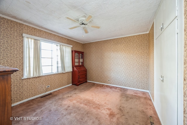 unfurnished bedroom with ceiling fan, carpet, a textured ceiling, and ornamental molding