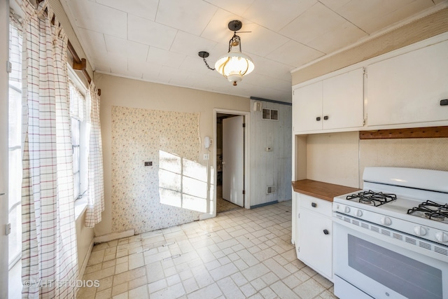 kitchen featuring hanging light fixtures, white cabinets, and white range with gas stovetop