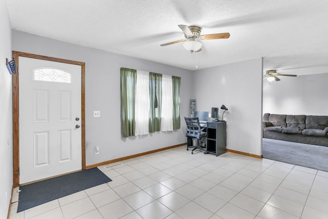 entrance foyer featuring ceiling fan, light tile patterned floors, a healthy amount of sunlight, and a textured ceiling