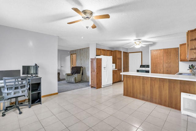 kitchen with kitchen peninsula, a textured ceiling, white appliances, heating unit, and light tile patterned flooring