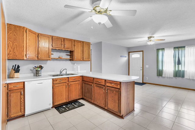 kitchen with sink, kitchen peninsula, white dishwasher, a textured ceiling, and light tile patterned floors