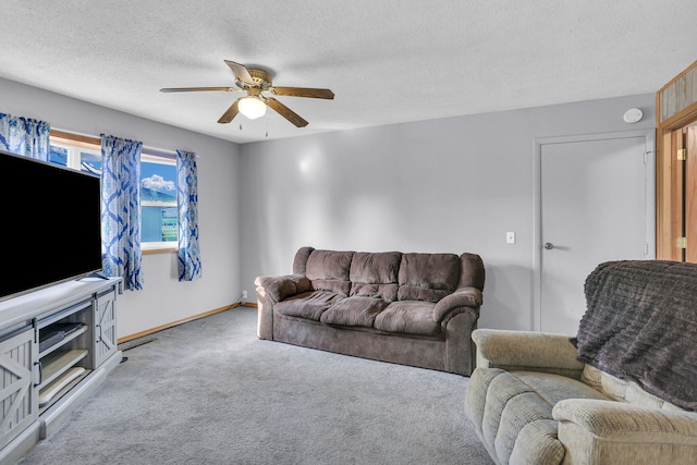 living room featuring a textured ceiling, light colored carpet, and ceiling fan