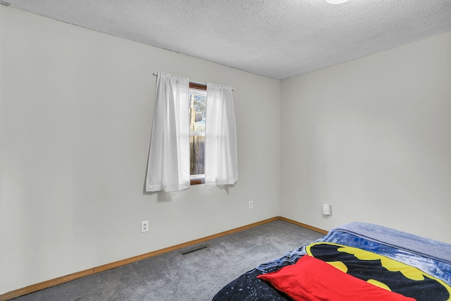 carpeted bedroom featuring a textured ceiling