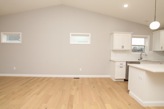 kitchen with white cabinetry, sink, decorative light fixtures, stainless steel dishwasher, and lofted ceiling