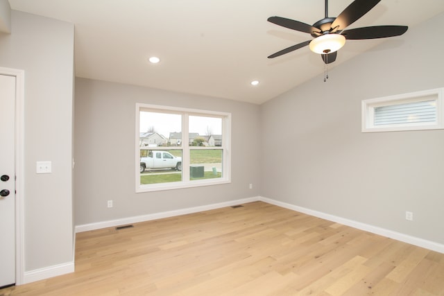 spare room featuring ceiling fan, light wood-type flooring, and lofted ceiling