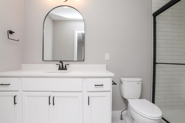 bathroom with a shower with door, vanity, and toilet