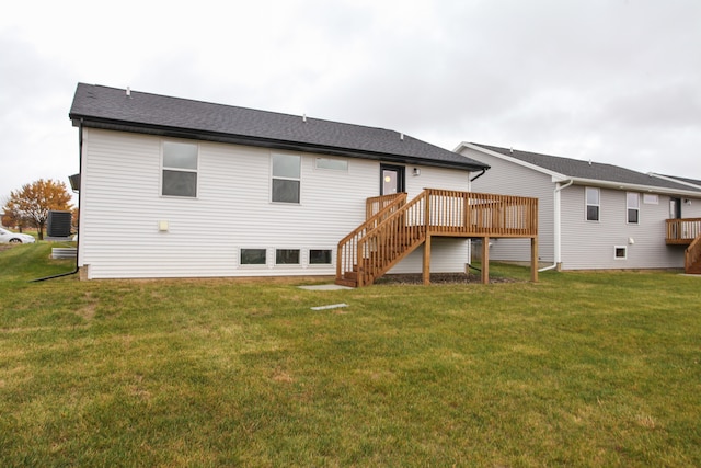 rear view of house featuring a lawn and a deck