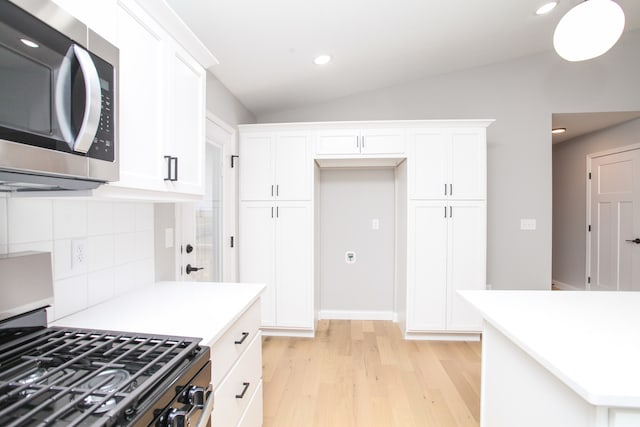 kitchen featuring stove and white cabinets